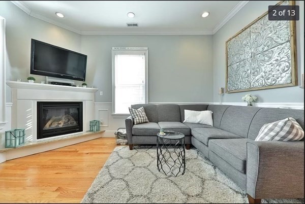 62 H Street, Unit 2 Boston, MA 02127 - Photo 2 of 12 a living room with furniture a flat screen tv and a fireplace