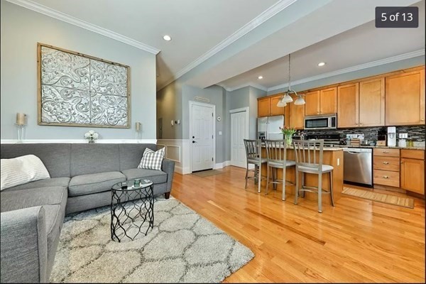62 H Street, Unit 2 Boston, MA 02127 - Photo 5 of 12 a living room with furniture a large window with kitchen view