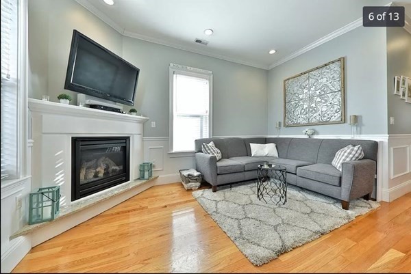 62 H Street, Unit 2 Boston, MA 02127 - Photo 6 of 12 a living room with furniture a flat screen tv and a fireplace