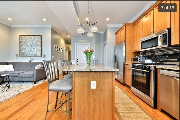 62 H Street, Unit 2 Boston, MA 02127 - Photo 7 of 12 a kitchen with stainless steel appliances granite countertop a stove a sink dishwasher and a refrigerator with wooden floor