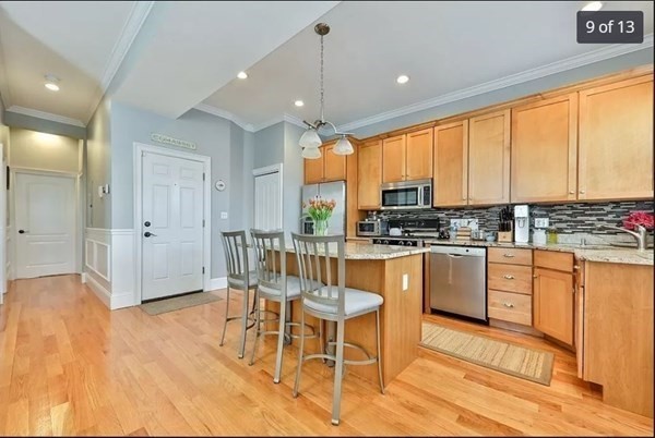 62 H Street, Unit 2 Boston, MA 02127 - Photo 8 of 12 a kitchen with granite countertop a stove a sink and white cabinets