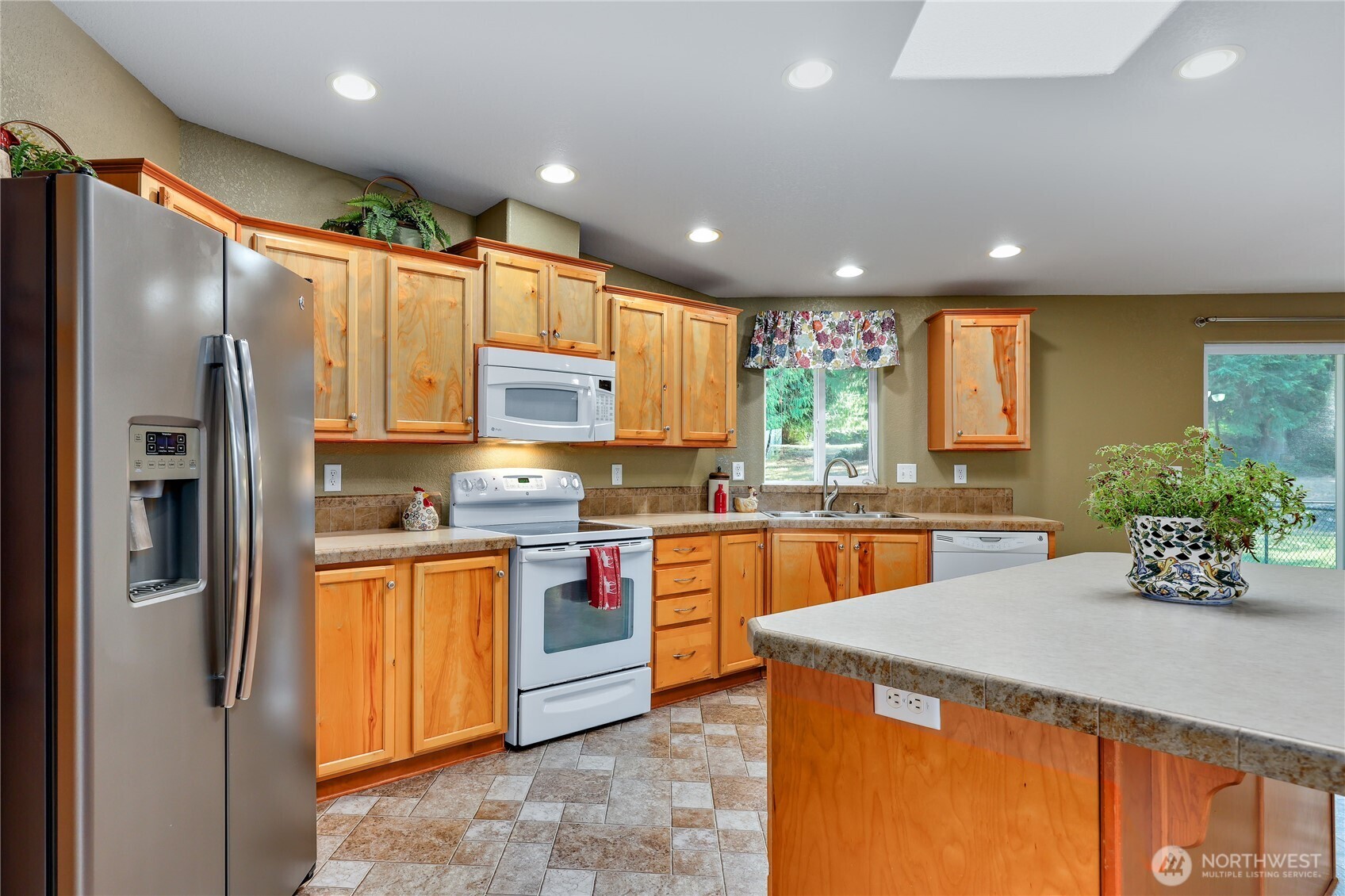 35025 Little Boston Road Northeast Kingston, WA 98346 - Photo 13 of 40 a kitchen with stainless steel appliances granite countertop a refrigerator a sink dishwasher a stove and a refrigerator with wooden floor