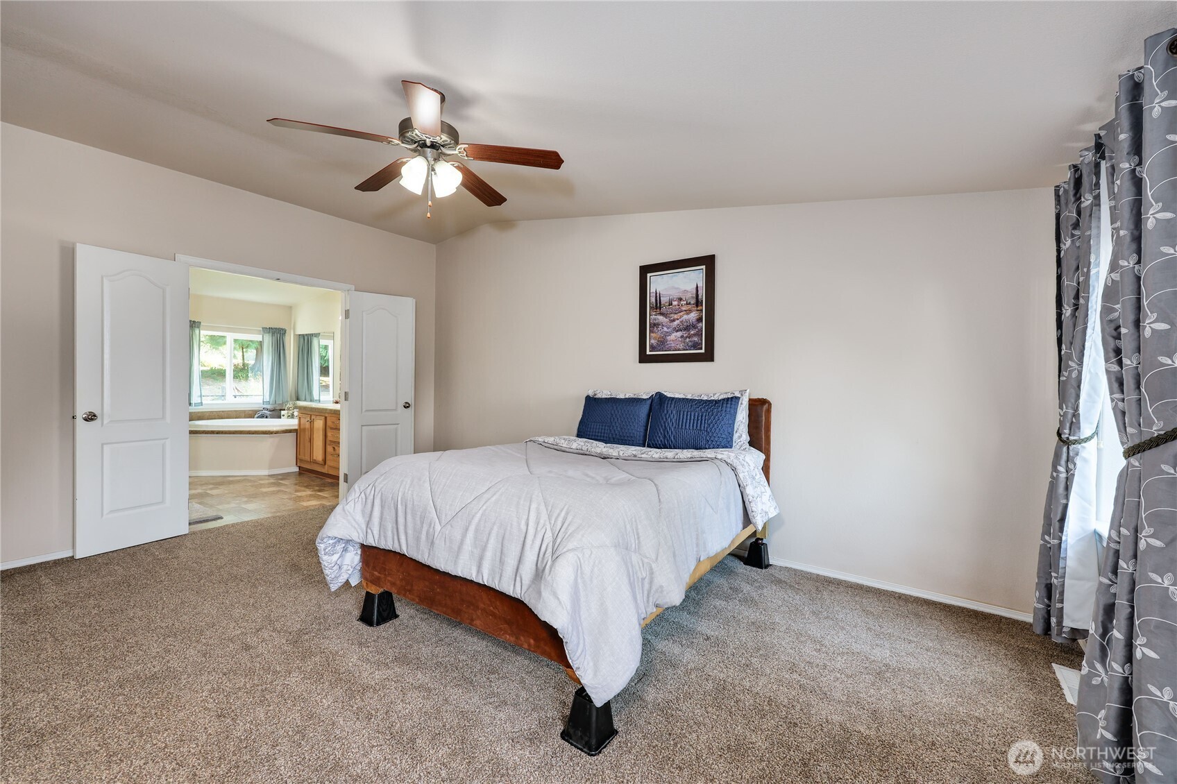 35025 Little Boston Road Northeast Kingston, WA 98346 - Photo 23 of 40 a spacious bedroom with a bed and a chandelier