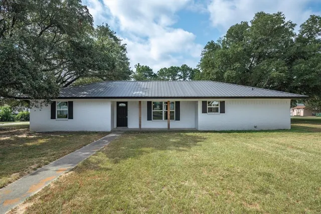 a large room with kitchen island a sink wooden floor and stainless steel appliances