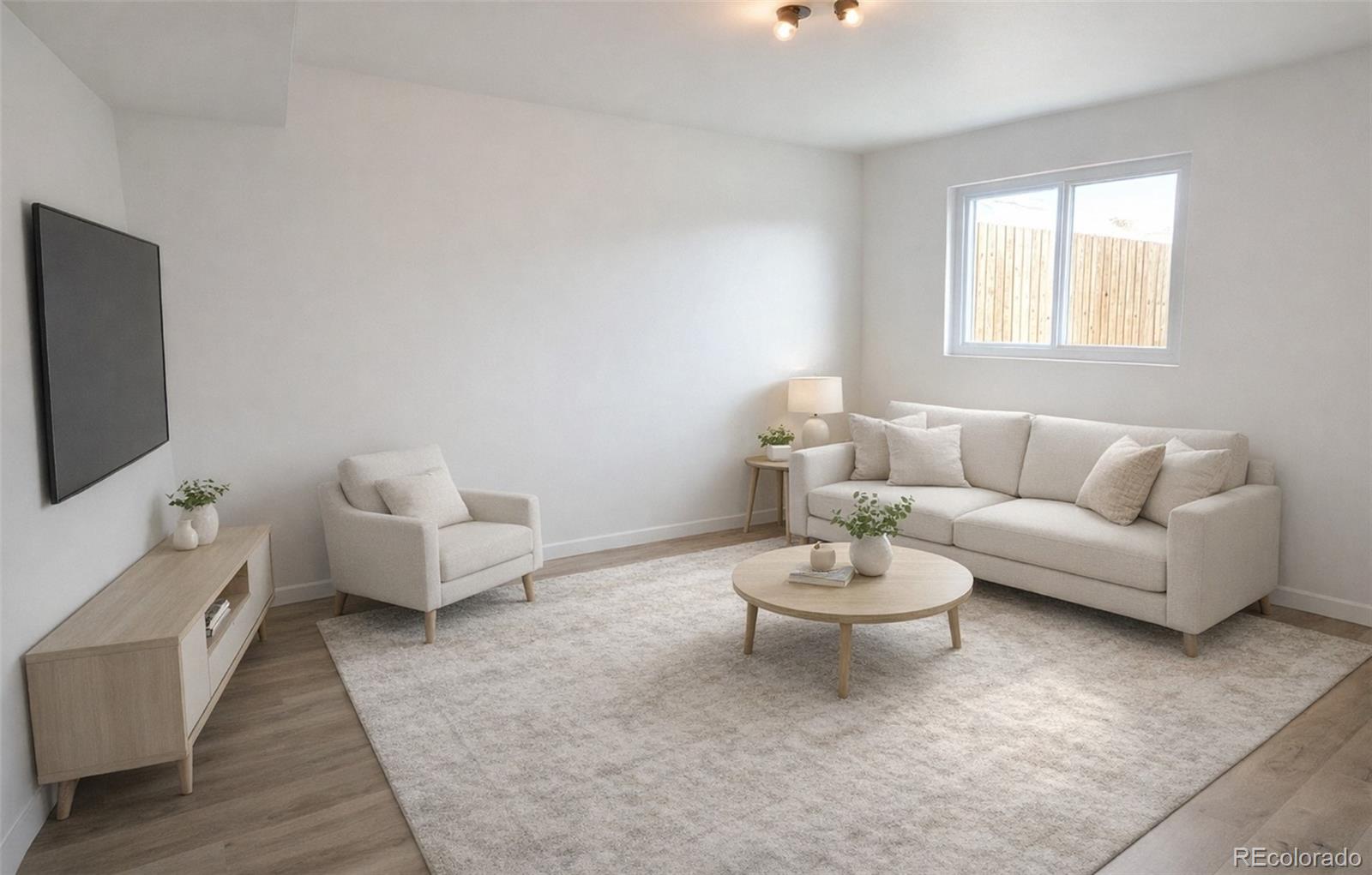 8128 Lafayette Street Denver, CO 80229 - Photo 12 of 19 a living room with furniture and a flat screen tv