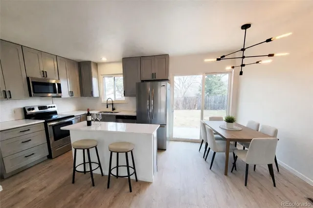 a kitchen with a table chairs refrigerator and microwave