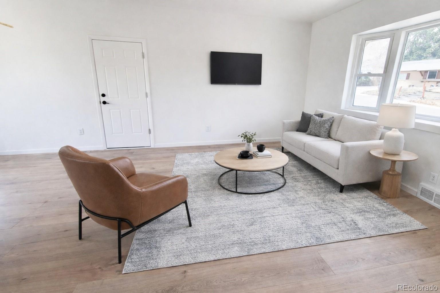 8128 Lafayette Street Denver, CO 80229 - Photo 5 of 19 a living room with furniture and a flat screen tv