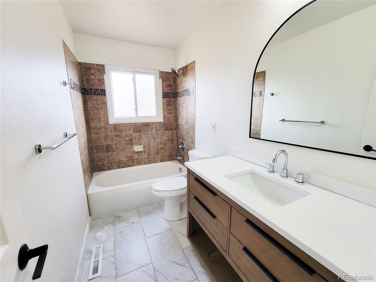 8128 Lafayette Street Denver, CO 80229 - Photo 8 of 19 a bathroom with a sink a toilet and bathtub