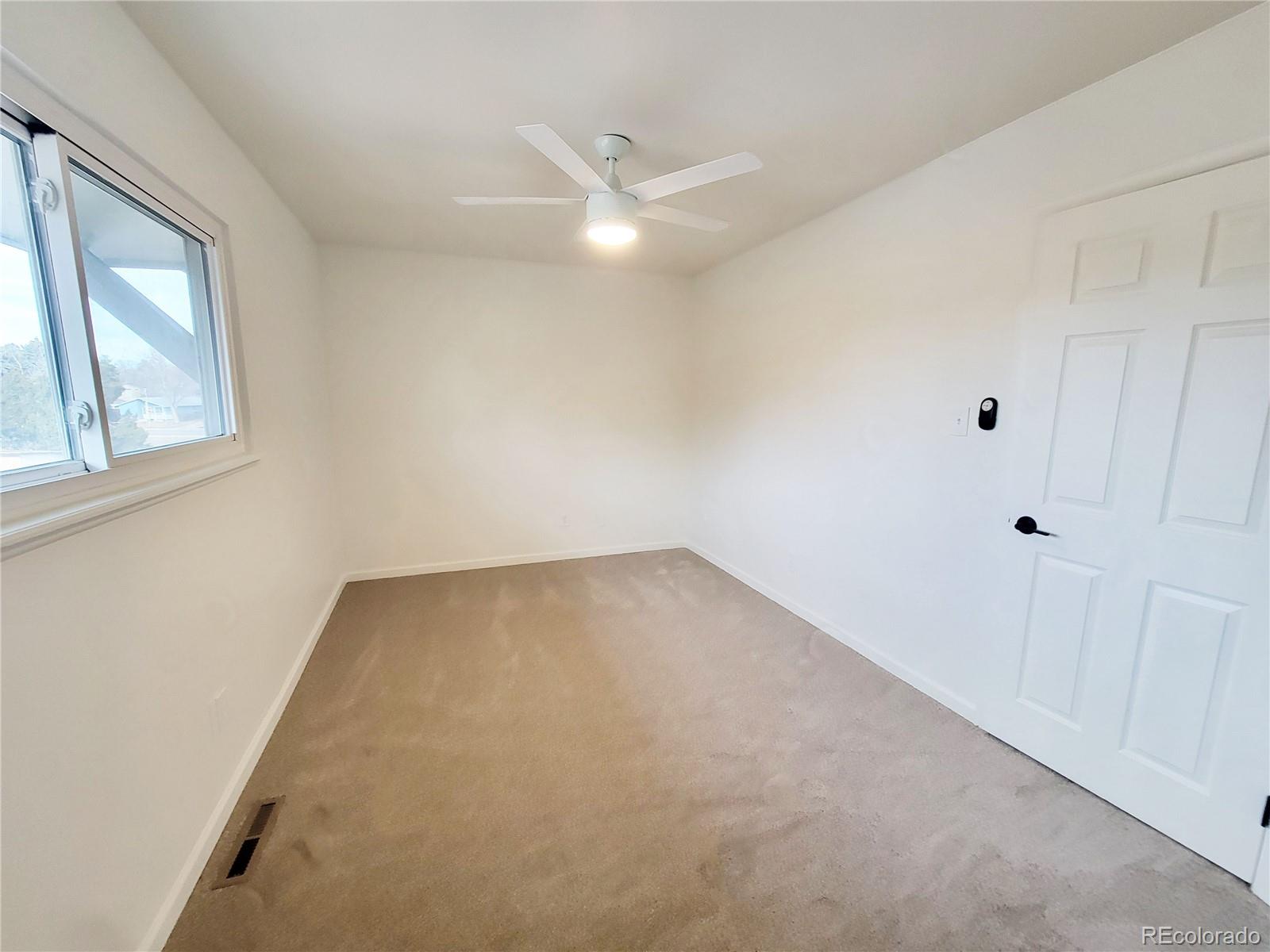 8128 Lafayette Street Denver, CO 80229 - Photo 10 of 19 an empty room with windows and fan
