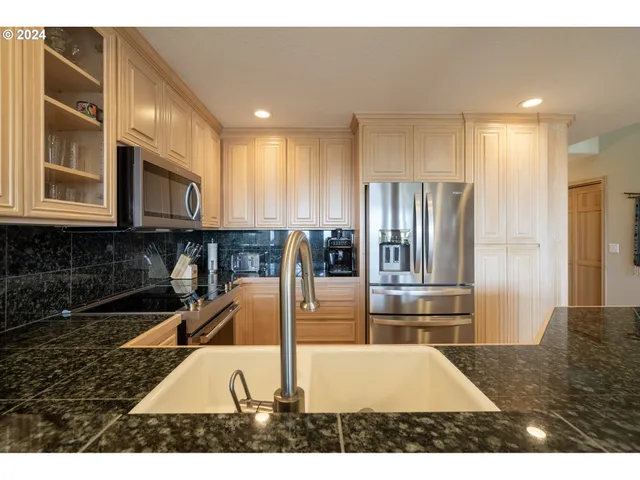 a kitchen with stainless steel appliances granite countertop a refrigerator and a sink