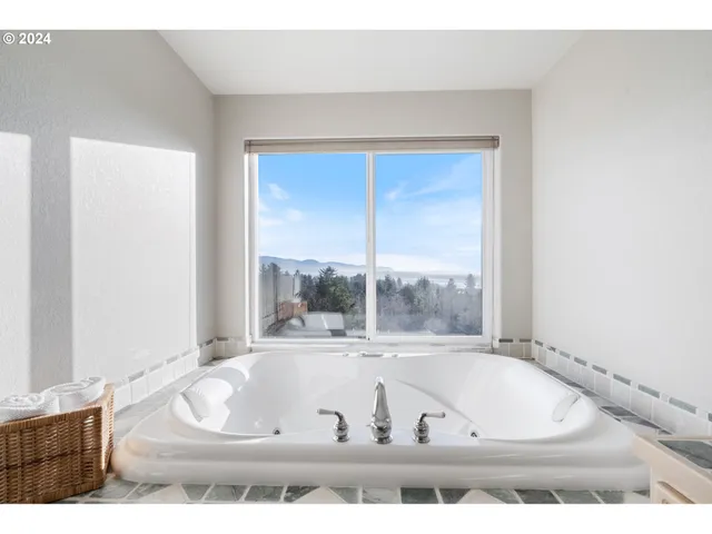 a view of bathroom with tub and windows