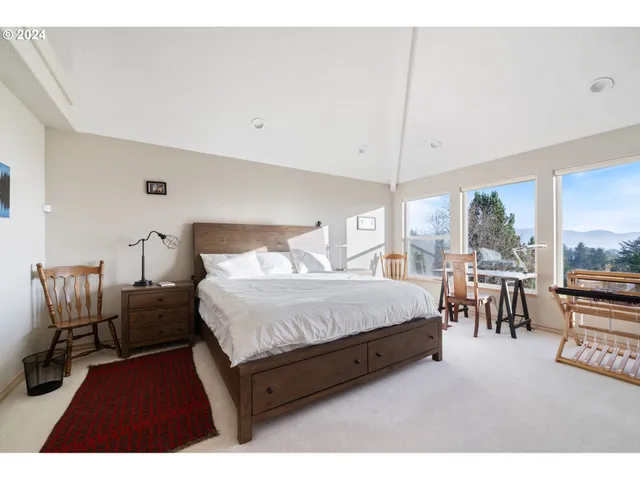 a bedroom with furniture and a large window