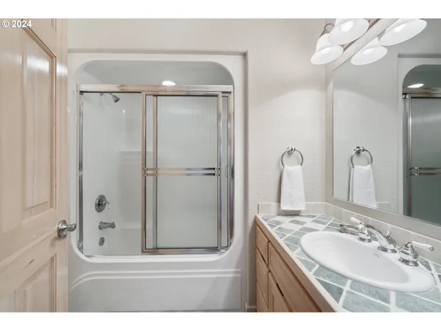 a bathroom with a granite countertop sink mirror and shower
