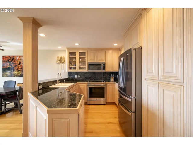 a kitchen with a refrigerator sink and cabinets
