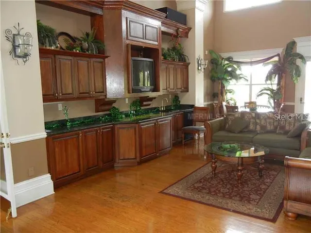 a kitchen with granite countertop a stove a sink and a wooden cabinets