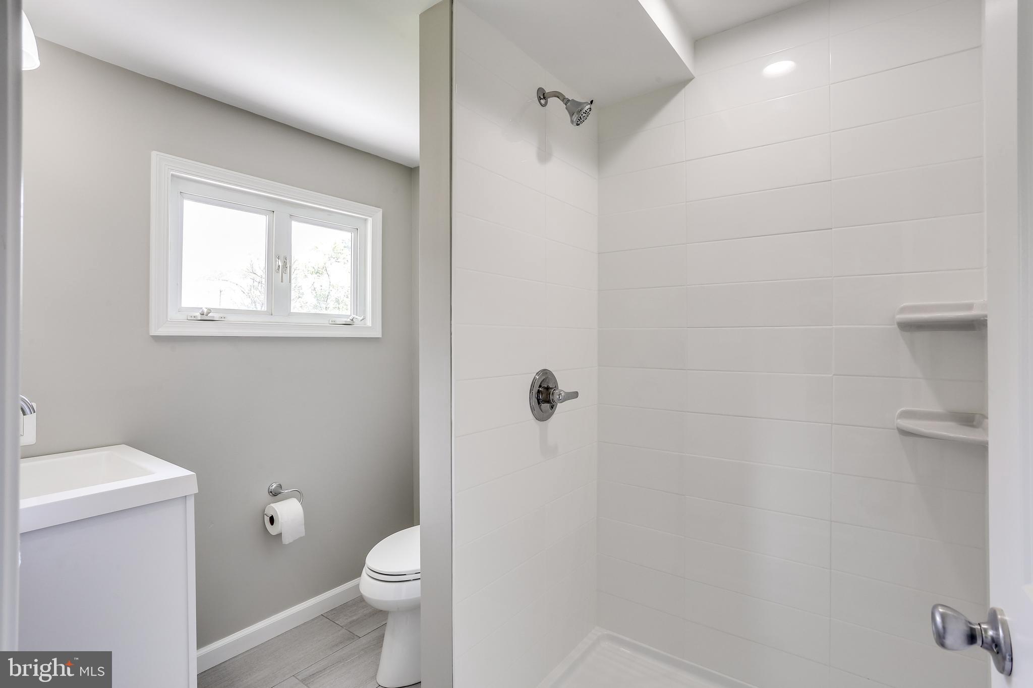 7106 Munford Road Baltimore, MD 21244 - Photo 16 of 31 a white toilet sitting next to a bathroom sink and vanity