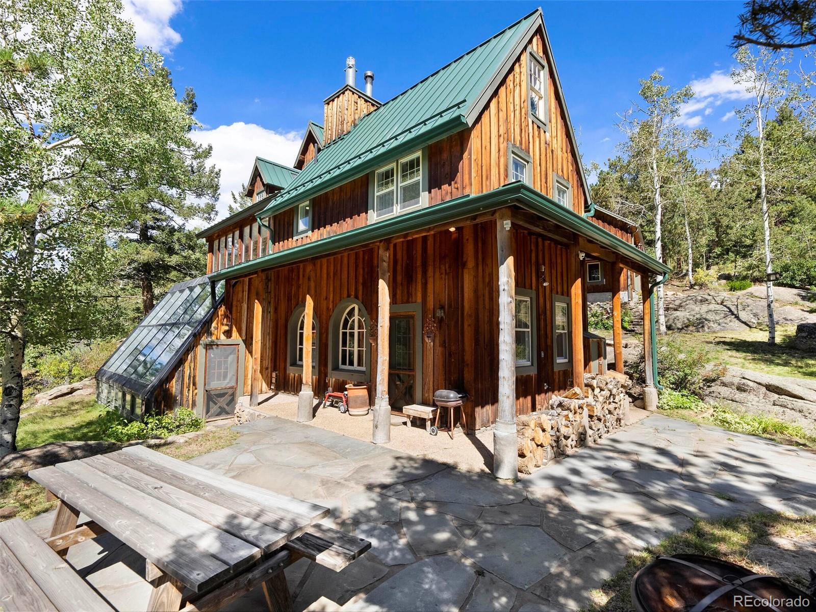 26795 Light Lane Conifer, CO 80433 - Photo 7 of 40 a wooden bench sitting in front of a house