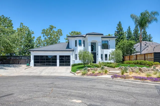 a front view of a house with a yard and potted plants