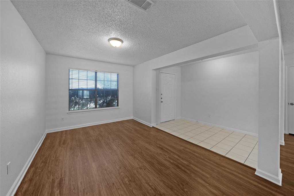 2910 Chisholm Trail Corinth, TX 76210 - Photo 3 of 30 an empty room with wooden floor and windows