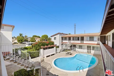 a front view of a building with cars parked