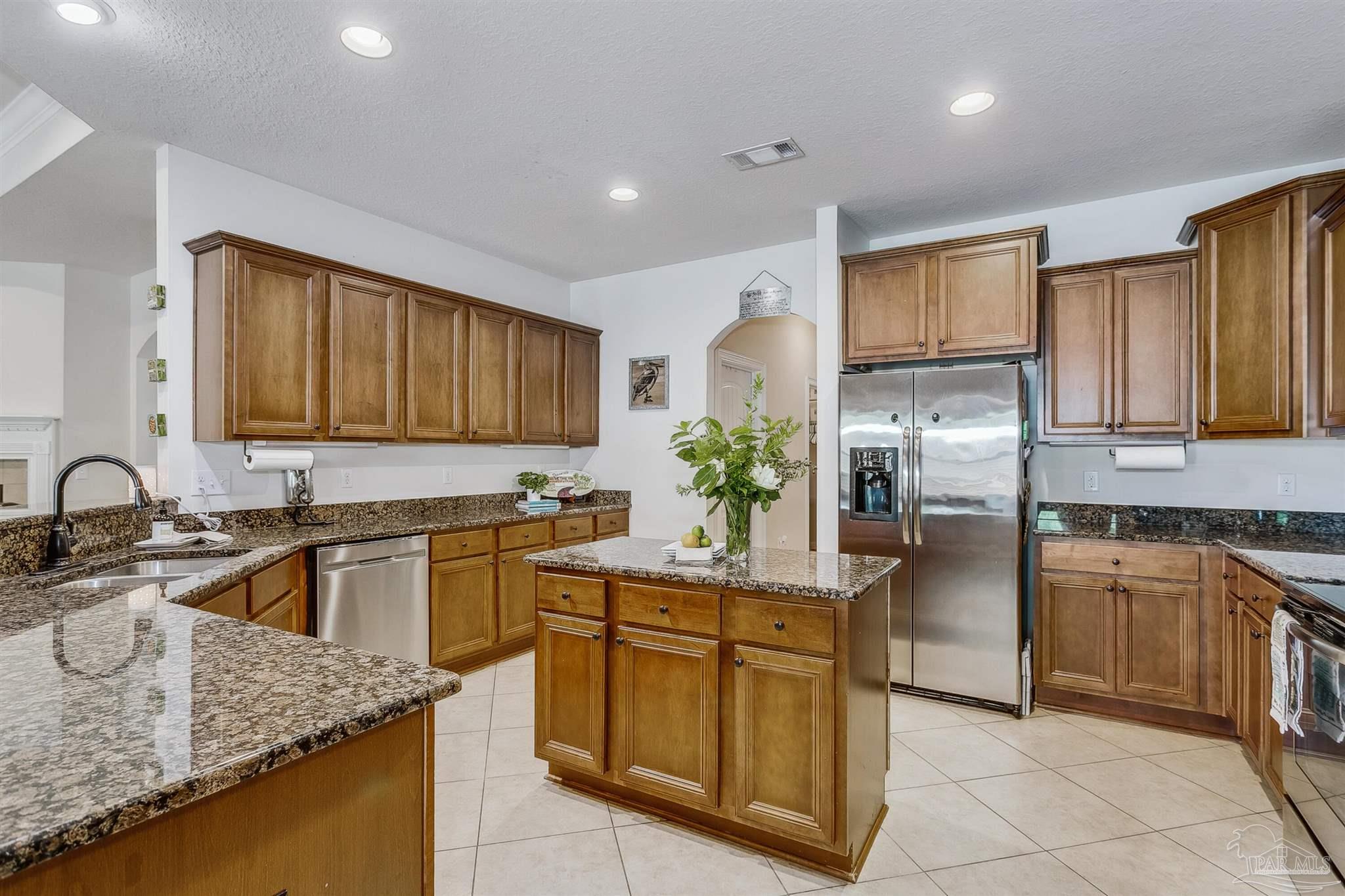 2072 Staff Drive Cantonment, FL 32533 - Photo 16 of 46 a kitchen with kitchen island granite countertop a sink stove and refrigerator