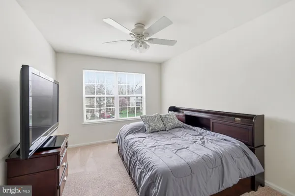 a bedroom with a large bed and a flat tv screen on a dresser