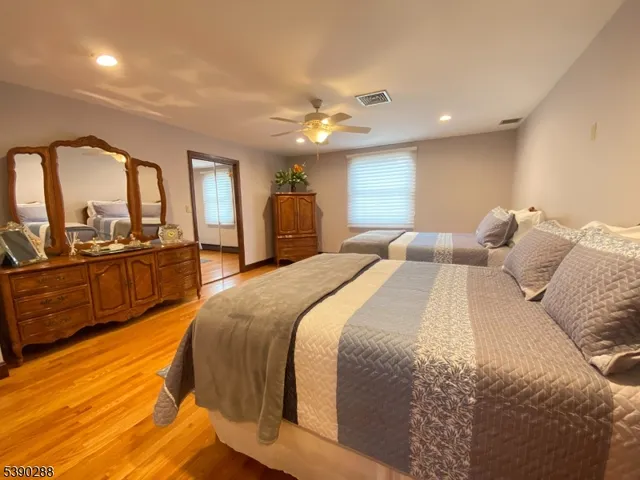 a spacious bedroom with a large bed and wooden floor