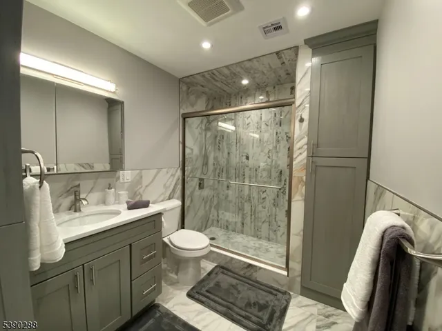 a bathroom with a sink a toilet and shower