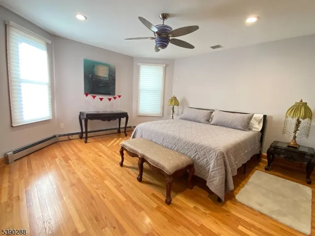 a spacious bedroom with a bed and a flat screen tv