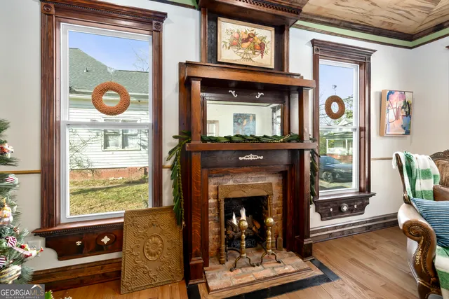 a dining room with wooden floor a chandelier fan a glass table and chairs