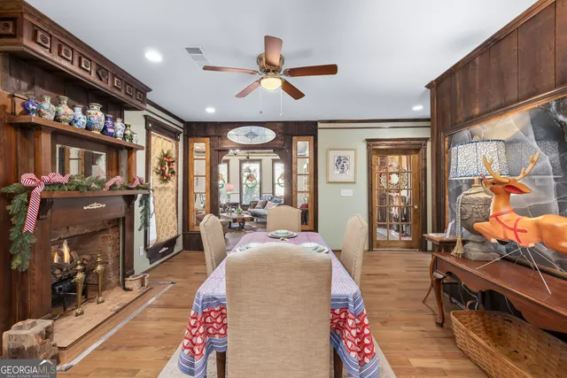 a kitchen with stainless steel appliances kitchen island granite countertop a refrigerator oven a sink dishwasher and white cabinets with wooden floor