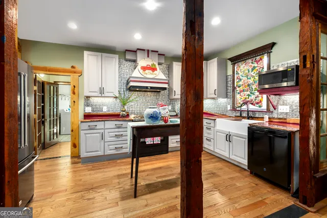 a kitchen with kitchen island granite countertop a sink stove and cabinets