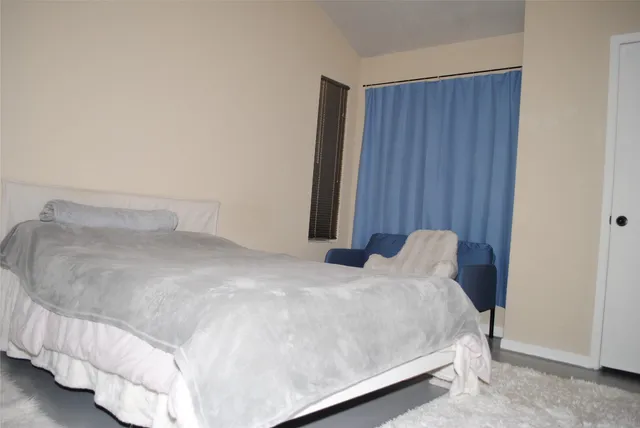 a bedroom with a bed and curtain