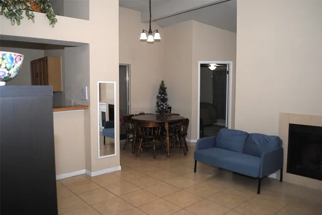 a living room with furniture a dining table and a chandelier