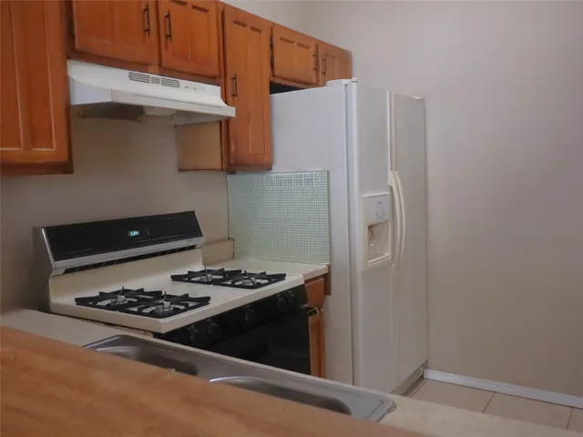 a kitchen with stainless steel appliances granite countertop a stove and a refrigerator