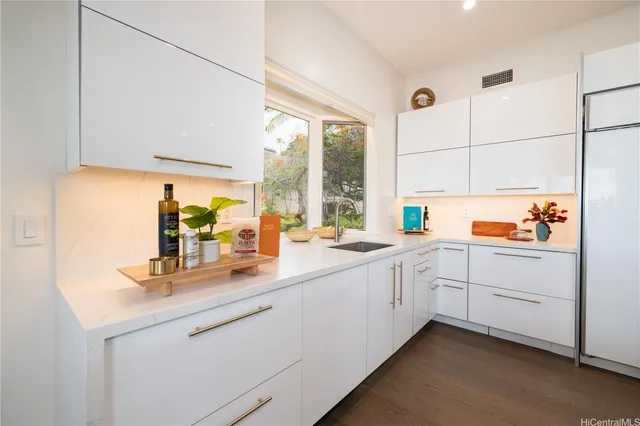 a kitchen with granite countertop white cabinets and white appliances