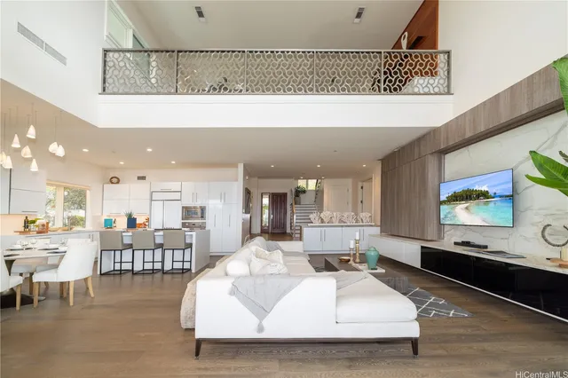 a living room with stainless steel appliances kitchen island granite countertop furniture and a flat screen tv