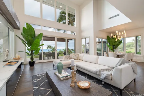 a living room with furniture and a large window with garden view