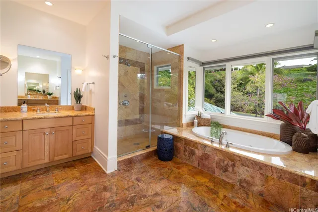 a spacious bathroom with a tub sink shower and mirror