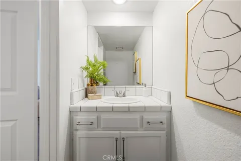 a bath room with a granite countertop sink and a mirror