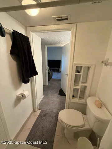 a white toilet sitting next to a bathroom sink and a mirror