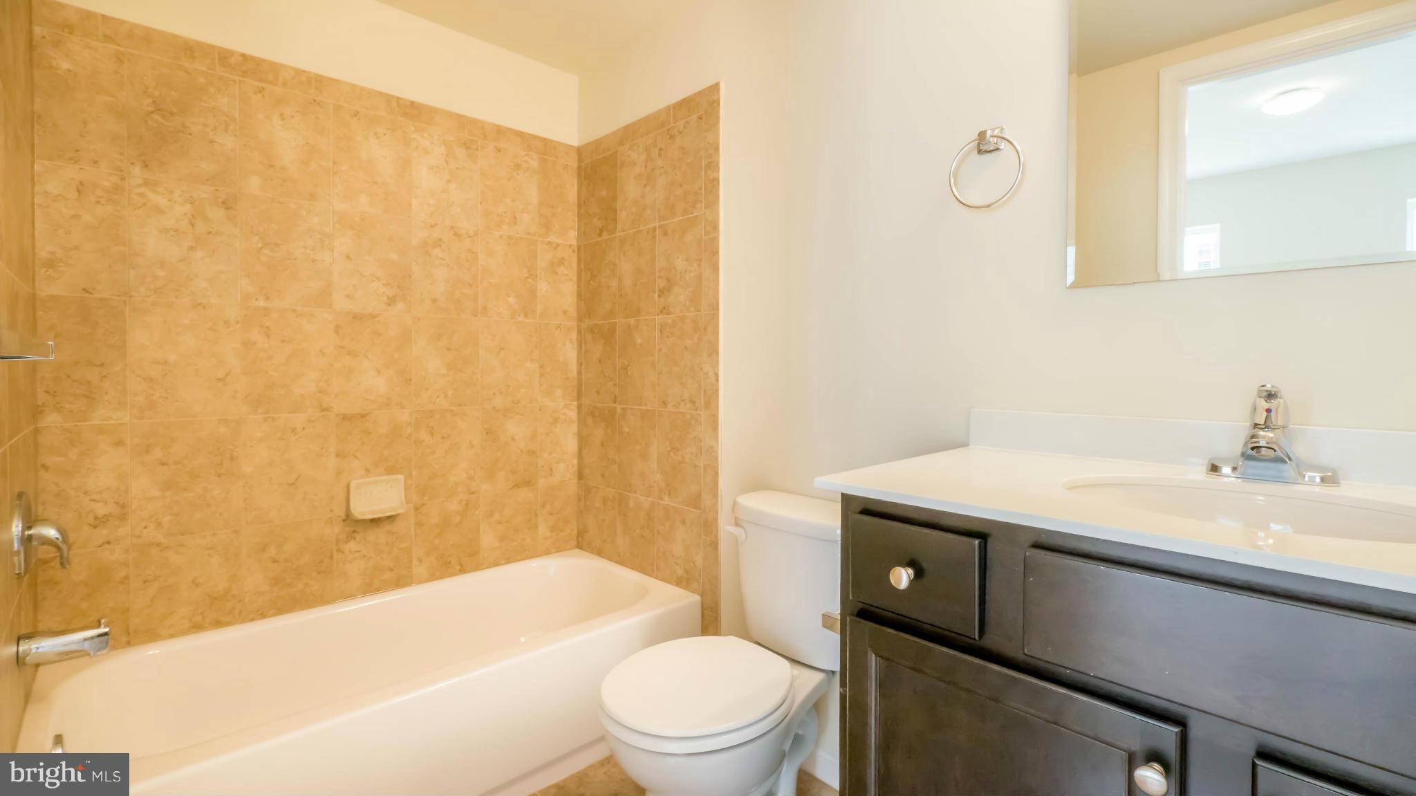 4628 Dillon Place Baltimore, MD 21224 - Photo 14 of 30 a bathroom with a sink a toilet and shower