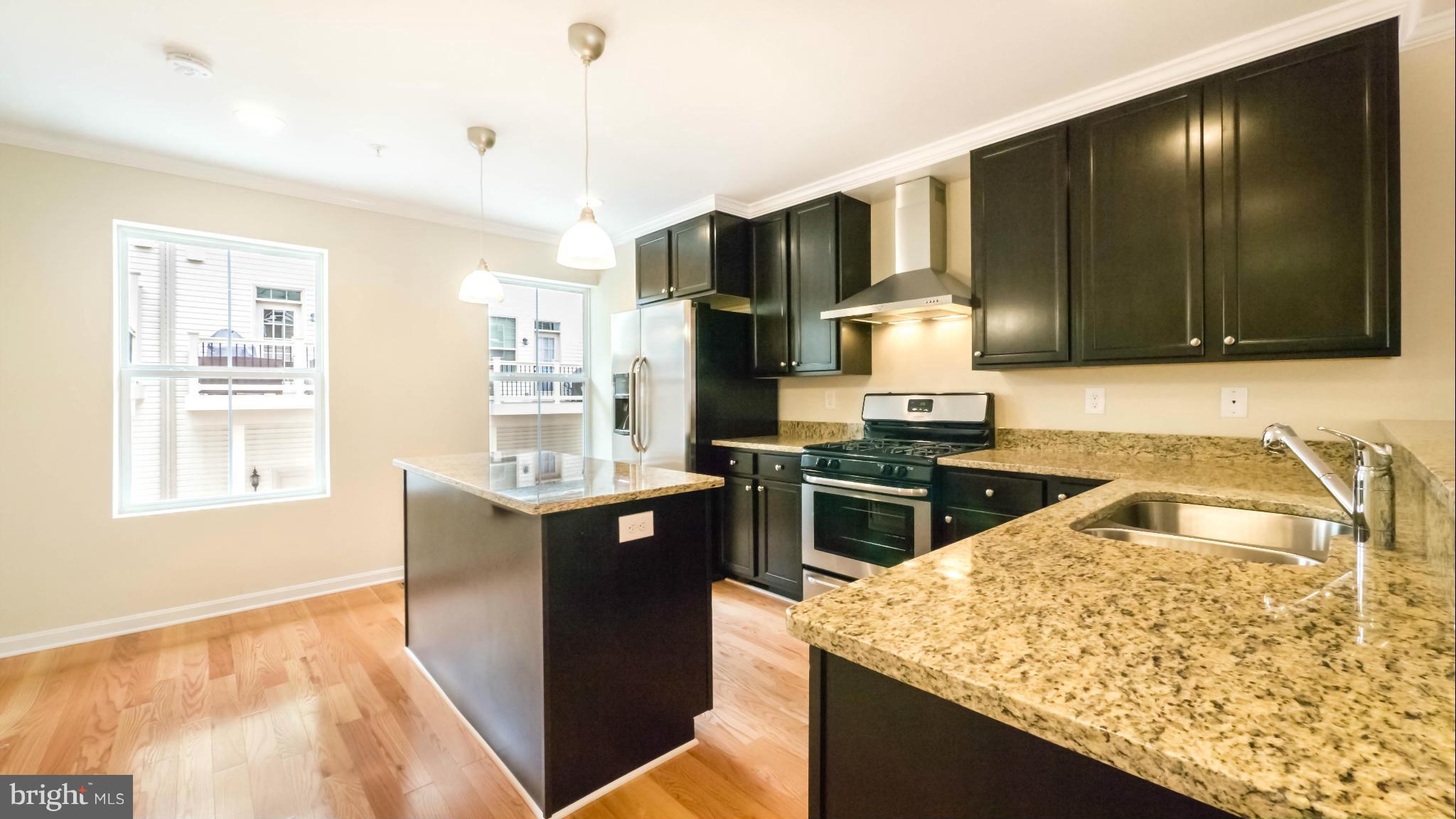 4628 Dillon Place Baltimore, MD 21224 - Photo 3 of 30 a kitchen with stainless steel appliances granite countertop a stove a sink and a microwave