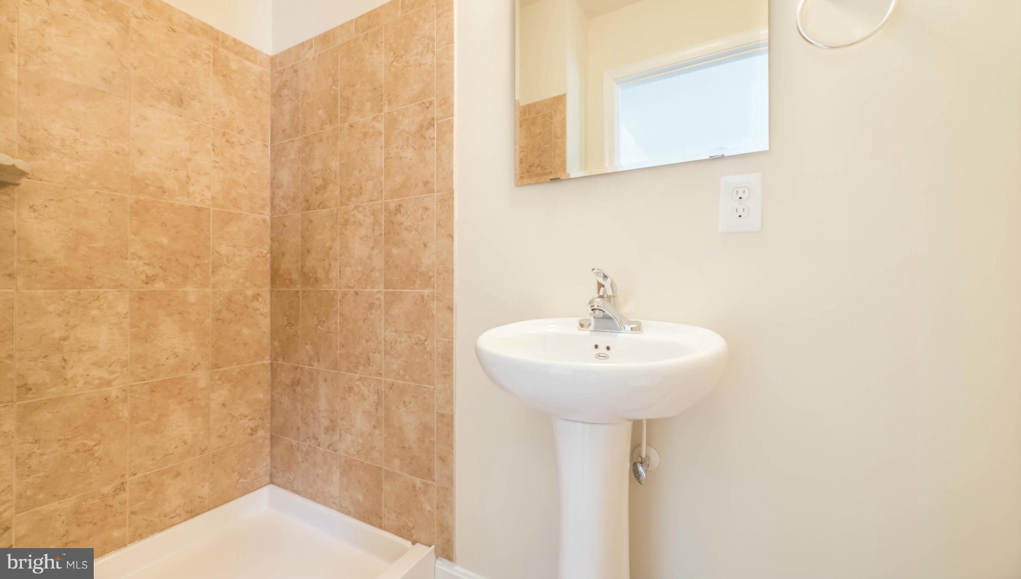 4628 Dillon Place Baltimore, MD 21224 - Photo 23 of 30 a bathroom with a sink a mirror and shower