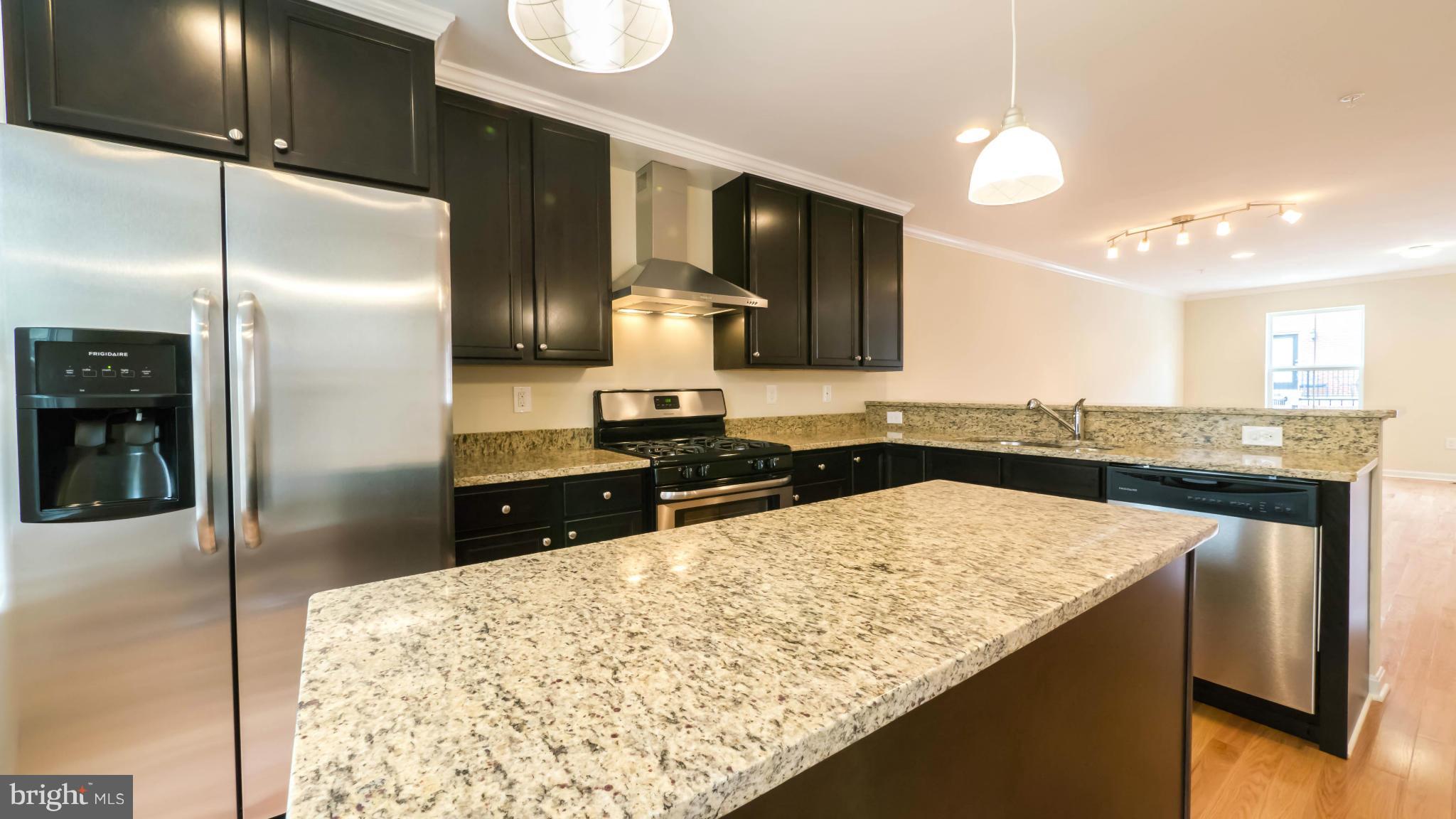4628 Dillon Place Baltimore, MD 21224 - Photo 4 of 30 a kitchen with stainless steel appliances granite countertop a sink refrigerator and cabinets