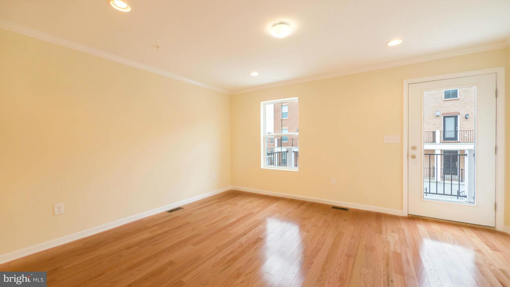 4628 Dillon Place Baltimore, MD 21224 - Photo 10 of 30 an empty room with wooden floor and windows