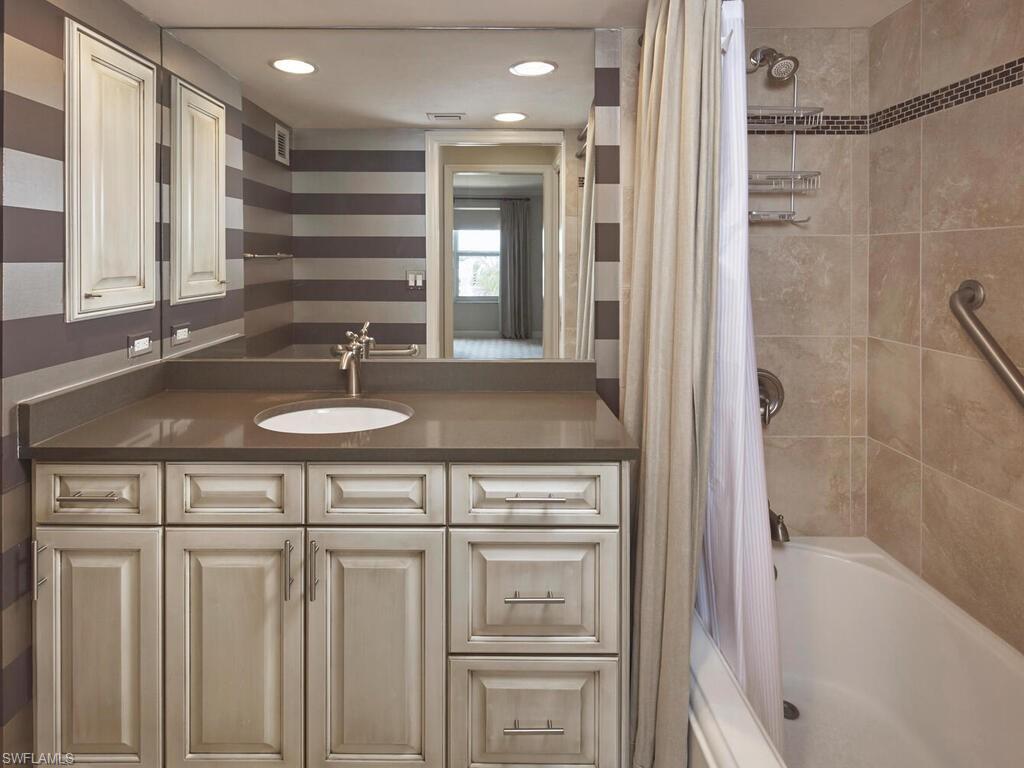 3003 Gulf Shore Boulevard North, Unit 604 Naples, FL 34103 - Photo 13 of 33 a bathroom with a sink a vanity and a bathtub