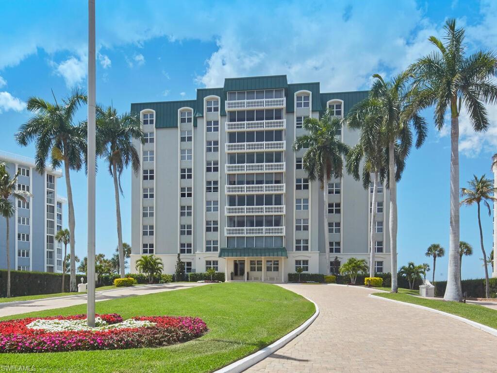 3003 Gulf Shore Boulevard North, Unit 604 Naples, FL 34103 - Photo 17 of 33 a front view of multi story residential apartment building with yard and green space
