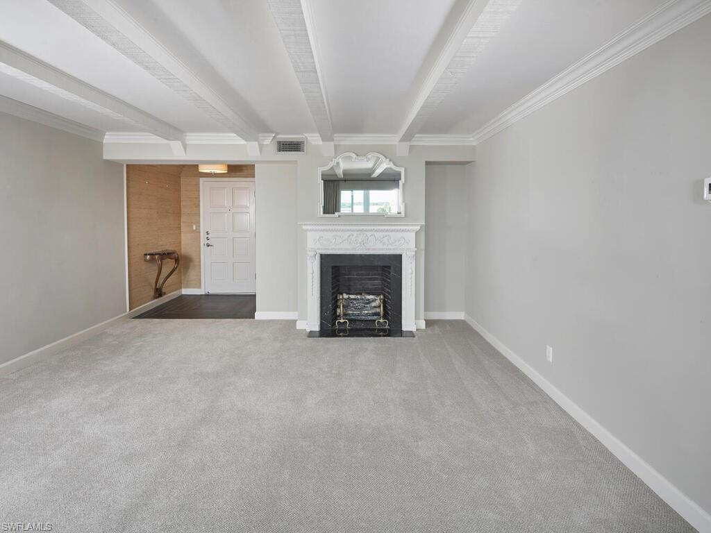 3003 Gulf Shore Boulevard North, Unit 604 Naples, FL 34103 - Photo 18 of 33 an empty room with fireplace and windows