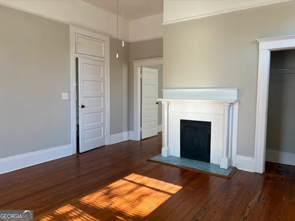 a view of a livingroom with wooden floor and a fireplace